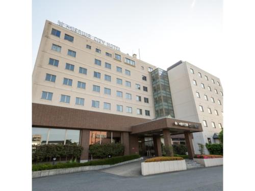 a large white building next to two tall buildings at Misawa City Hotel - Vacation STAY 81780v in Misawa