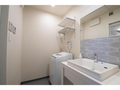y baño con lavabo y lavadora. en Hotel Celeste Shizuoka Takajo - Vacation STAY 94075v en Shizuoka