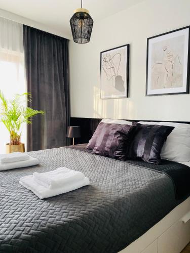 a bedroom with a bed with two towels on it at Motlawa Inn Apartment-Suna,Gym&Parking in Gdańsk