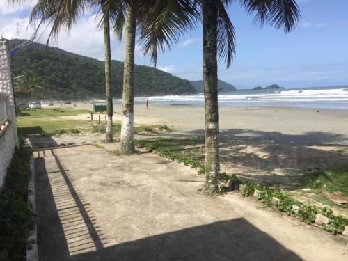um caminho que leva a uma praia com palmeiras em Pousada Lambaris Pereque Guarujá no Guarujá