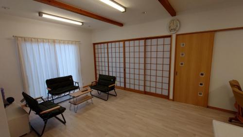 ein Zimmer mit zwei Stühlen und einer Uhr an der Wand in der Unterkunft Yokombo 2 Pet friendly inn - Vacation STAY 22296v in Kagawa