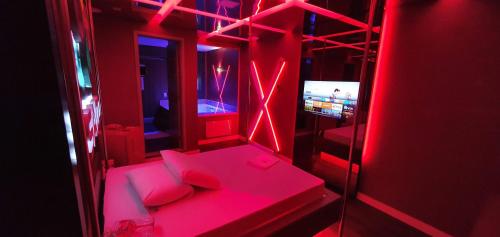 um quarto vermelho com um sofá e uma televisão em Motel Fantasy 3 (Adult Only) em Belo Horizonte