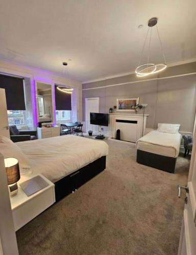a large bedroom with a bed and a living room at Luxury Family Room With Private bathroom in the heart of Edinburgh in Edinburgh