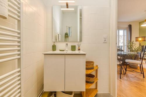 La salle de bains blanche est pourvue d'un lavabo et d'un miroir. dans l'établissement Entre gare et centre-ville: lit double, wifi, à Grenoble