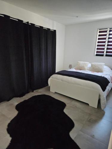 a bedroom with a bed with black curtains and a black rug at Bas de villa au calme in Marseille
