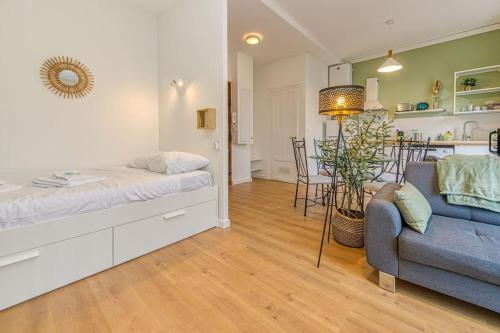 a bedroom with a bed and a couch and a kitchen at Entre gare et centre-ville: lit double, wifi in Grenoble