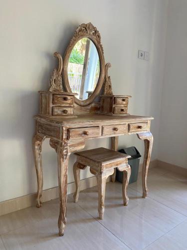 an old wooden dressing table with a mirror and a stool at Comeon Amed in Amed