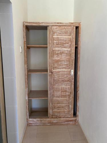 a closet with a wooden door in a room at Comeon Amed in Amed