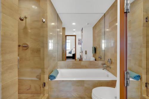 a bathroom with a tub and a toilet and a shower at Brickell Bliss - Luxury Condo in Miami