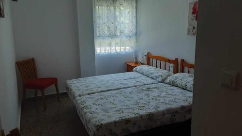 1 dormitorio con 1 cama, 1 silla y 1 ventana en Villa les palmiers, en Rafelguaraf