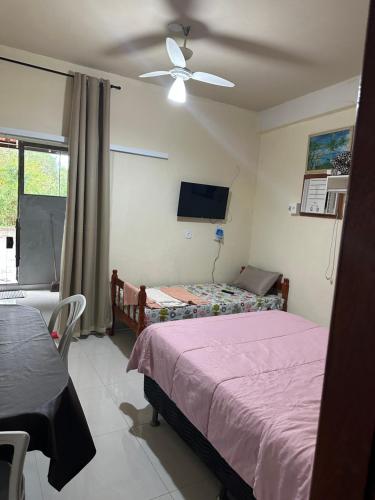 a bedroom with a bed and a ceiling fan at Flat da Praia Rio das Ostras in Rio das Ostras