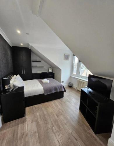 a bedroom with a bed and a flat screen tv at Luxury Double Room With Private Bathroom in Edinburgh