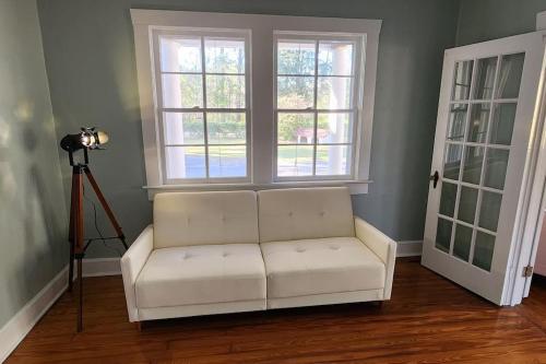 a white couch in a room with two windows at A retro rejuvenation in Midway