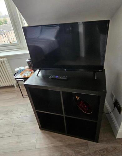 a black entertainment center with a large flat screen tv at Luxury Double Room With Private Bathroom in Edinburgh