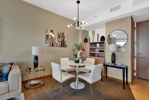 a living room with a table and white chairs at Brickell Bliss - Luxury Condo in Miami