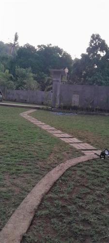a stone path in a grass field with a building at Comeon Amed in Amed