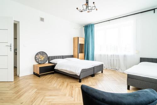 1 dormitorio con 2 camas y sofá en Warszawska 206 II Piętro, en Radom