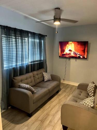 オーランドにある3bdrm modern entertainment homeのソファとテレビのあるリビングルーム