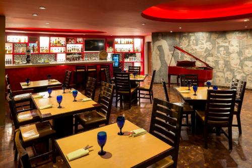 a restaurant with tables and chairs and a piano at Camino Real Guadalajara in Guadalajara