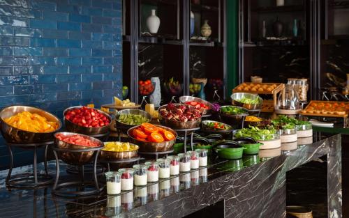 a buffet with many bowls of food on a counter at InterContinental Tashkent by IHG in Tashkent