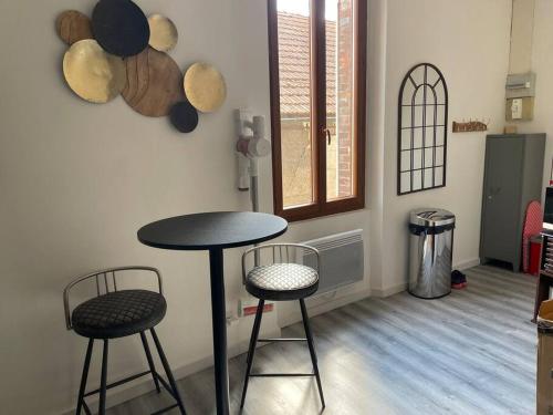 une chambre avec une table et deux tabourets dans l'établissement Le Citadin, à Sens