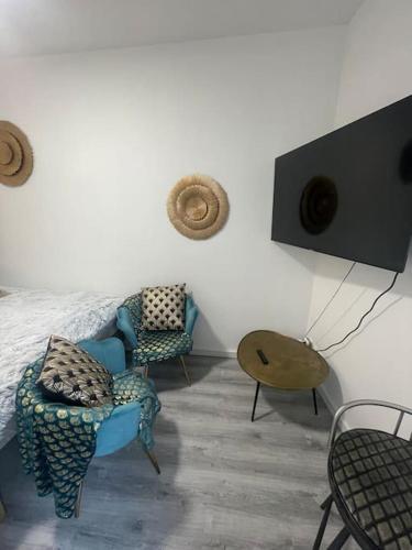 - une chambre avec deux chaises, un lit et une table dans l'établissement Le Citadin, à Sens