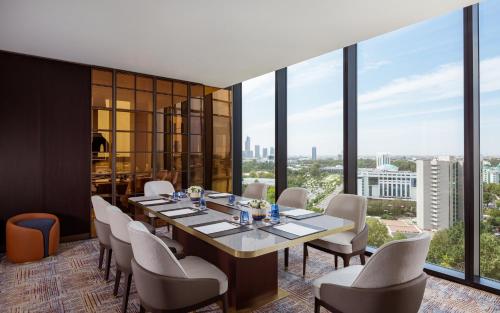 a dining room with a table and chairs and large windows at InterContinental Tashkent by IHG in Tashkent