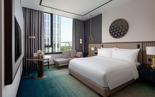 a hotel room with a bed and a desk and a chair at InterContinental Tashkent by IHG in Tashkent