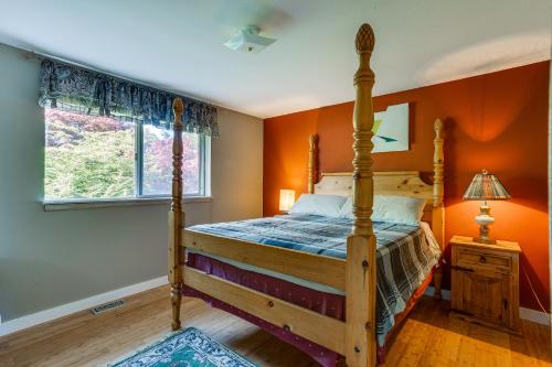 フェデラルウェイにあるFederal Way Vacation Rental Bay and Mountain Views!のオレンジ色の壁のベッドルーム1室(木製ベッド1台付)