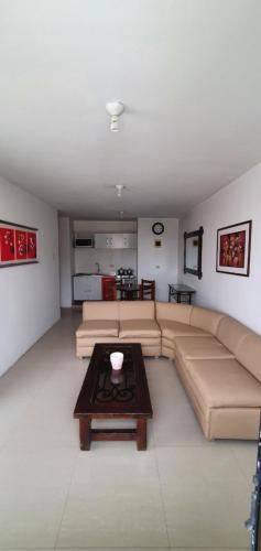 a living room with a couch and a coffee table at Departamentos en Playa Pulpos HOSPEDAJE DELFINES HOUSE in Lurín