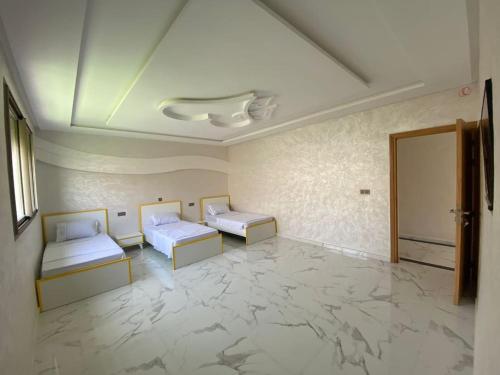 Cette chambre dispose de 2 lits et d'un sol en marbre. dans l'établissement Villa avec piscine à Agadir, à Agadir