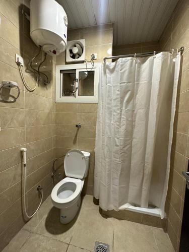 a bathroom with a toilet and a shower at فندق المقام السامي للغرف والشقق المفروشة in Makkah