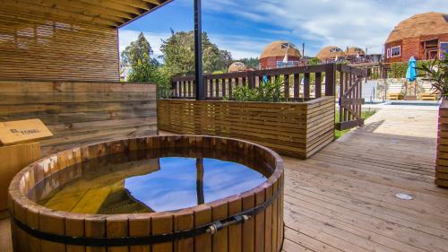 a wooden deck with a hot tub on top of it at Pichilemu Domos in Pichilemu