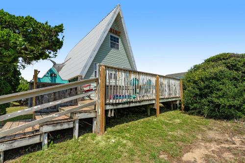 a small blue house with a fence in front of it at Anchor's Holding in Holden Beach