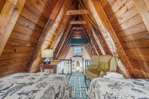 a bedroom in a log cabin with two beds and a chair at Anchor's Holding in Holden Beach