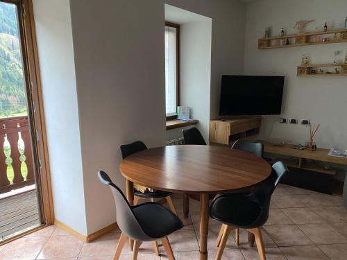 a dining room with a table and chairs and a television at Appartamento Ari in Vermiglio