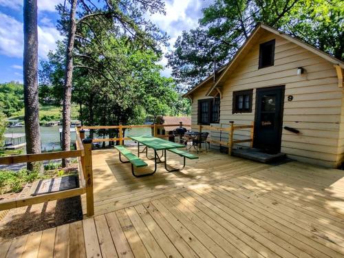 eine Holzterrasse mit einem Picknicktisch und einem Haus in der Unterkunft #09 - Large Lakeview One Bedroom- Pet Friendly in Hot Springs