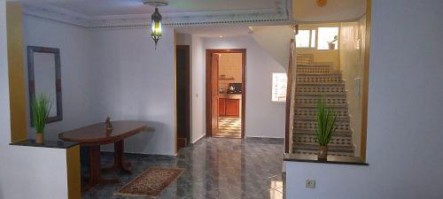um quarto com um corredor com uma mesa e escadas em Duplex Malika em El Jadida