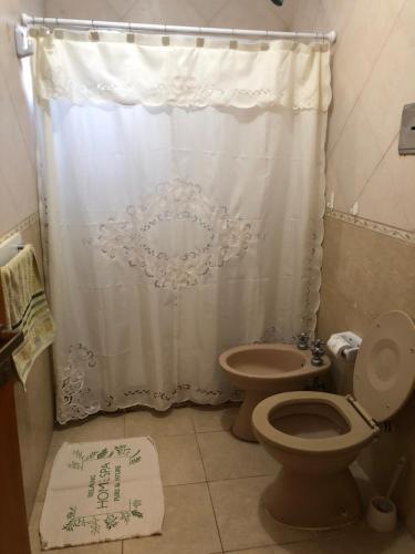 a bathroom with a toilet and a shower curtain at Sans Souci in Gualeguaychú