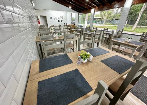 an empty restaurant with wooden tables and chairs at HLN Hotel - Expo - Anhembi in São Paulo