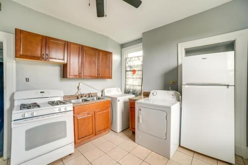 a kitchen with white appliances and wooden cabinets at Pittsburgh Vacation Rental about 6 Mi to Downtown! in Pittsburgh