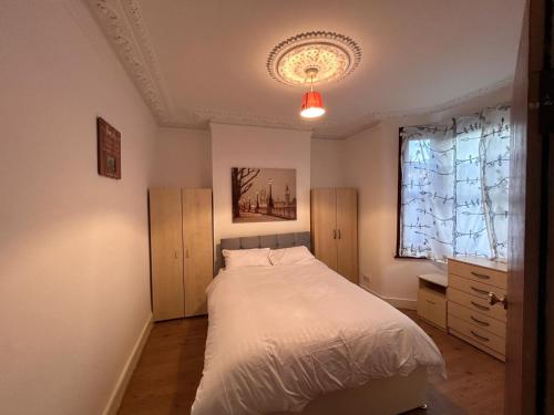 a bedroom with a white bed and a window at House in Walthamstow in London