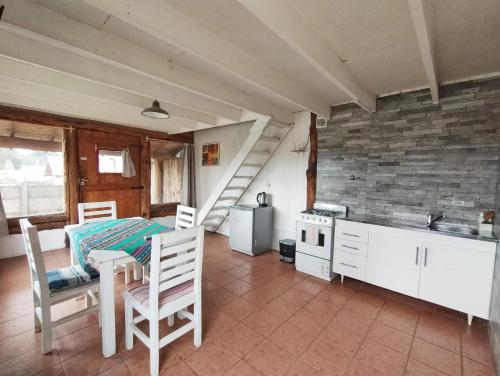 Una cocina con una mesa y sillas en una habitación. en 4 Vientos, en Villa La Angostura