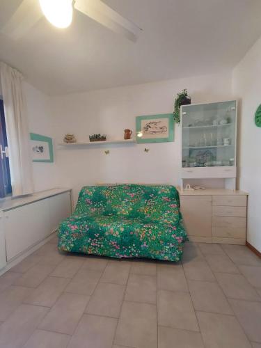 - une chambre avec un lit et une couverture verte dans l'établissement Punta Negra holyday, à Stintino