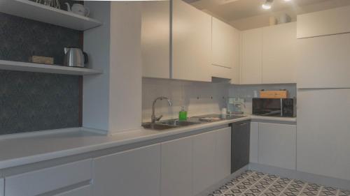 a kitchen with white cabinets and a sink at Il Biru in Montelupo Albese