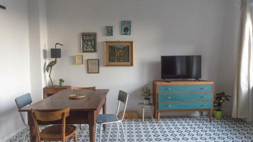 a dining room with a table and a television on a dresser at Il Biru in Montelupo Albese