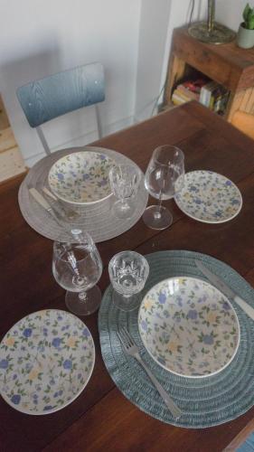 a wooden table with plates and glasses on it at Il Biru in Montelupo Albese