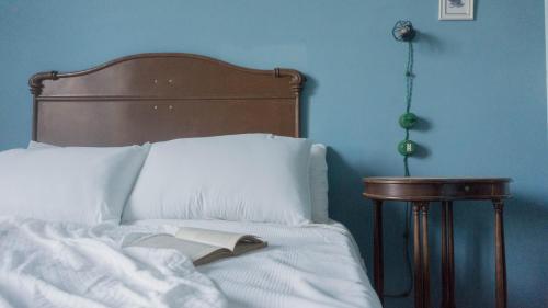 a bed with white sheets and a book on it at Il Biru in Montelupo Albese