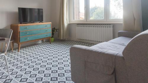a living room with a couch and a tv and a dresser at Il Biru in Montelupo Albese