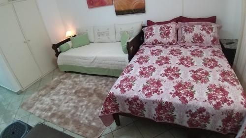 um quarto com uma cama e um sofá em Flat 206 Hotel Cavalinho Branco (3 piscinas, elevador, sauna) em Águas de Lindóia
